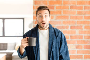 Yakışıklı adam çok şaşırmış ya da şaşkın görünüyor, ağzı açık bir şekilde 