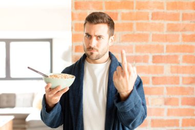 Yakışıklı adam kızgın, sinirli, isyankar ve agresif orta parmağını sallayarak karşılık veriyor.