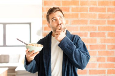 Yakışıklı düşünen, kuşkulu ve kafası karışık, farklı seçenekleri olan, hangi kararı vereceğini merak eden bir adam.