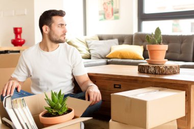 Profil görünümünde yakışıklı bir adam uzayı kopyalamaya çalışıyor, düşünüyor, hayal ediyor ya da hayal kuruyor.