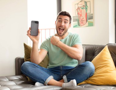 Yakışıklı adam mutlu, pozitif ve başarılı hissediyor, bir meydan okumayla karşılaştığında motive oluyor veya iyi sonuçları kutluyor.