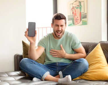 Yakışıklı bir adam komik bir şakaya gülüyor, mutlu ve neşeli hissediyor, eğleniyor.