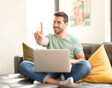 Yakışıklı adam gururla gülümsüyor ve gururla bir numaralı pozunu veriyor, kendini lider gibi hissediyor.