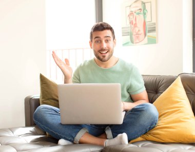 Yakışıklı adam kendini mutlu, şaşırmış ve neşeli hissediyor. Pozitif bir tavırla gülümsüyor. Bir çözüm ya da fikir buluyor.