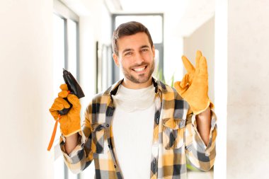 Tamirci kendini mutlu, rahat ve tatmin olmuş hissediyor. Onayını iyi bir hareketle gösteriyor. Gülümsüyor.