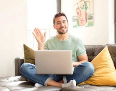 Yakışıklı adam mutlu ve neşeyle gülümsüyor, el sallıyor, seni selamlıyor ya da hoşça kal diyor.