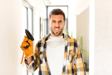 Becerikli adam tiksinmiş ve sinirlenmiş hissediyor, dilini dışarı çıkarıyor, iğrenç ve iğrenç bir şeyden hoşlanmıyor.