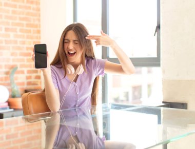 Güzel bir kadın mutsuz ve stresli görünüyor, intihar jesti elle silah işareti yapıyor, kafasını işaret ediyor.