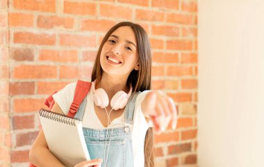 Tatmin olmuş, kendine güvenen, dost canlısı bir gülümsemeyle kameraya bakıp seni seçiyor.