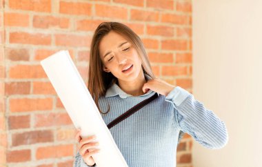 Güzel bir mimar stresli, endişeli, yorgun ve hayal kırıklığına uğramış, gömleğini çekmiş, sıkıntılı görünüyor.