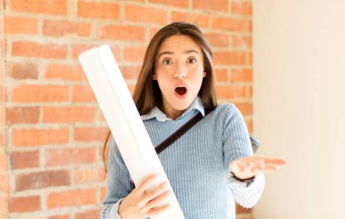 Güzel bir mimar aşırı derecede şok olmuş ve şaşırmış, endişeli ve paniklemiş, stresli ve dehşete kapılmış görünüyor.