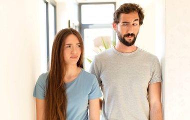 Genç çift üzgün, üzgün ya da kızgın hissediyor ve olumsuz bir tavırla, anlaşmazlık içinde somurtuyor.