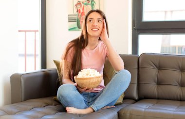 Gülümseyerek mutlu ve hayal kurarak ya da şüphe duyarak, yan tarafa bakarak