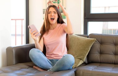 Güzel bir kadın elleri havada bağırıyor. Öfkeli, sinirli, stresli ve üzgün.