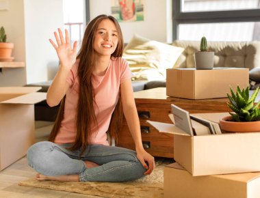 Güzel bir kadın gülümsüyor ve arkadaş canlısı görünüyor, 5 ya da 5 numarayı gösteriyor, elleri önde, geriye doğru sayıyor.