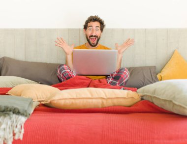 Genç sakallı adam mutlu, heyecanlı, şaşırmış ya da şok olmuş hissediyor. İnanılmaz bir şeye gülümsüyor ve hayrete düşüyor.