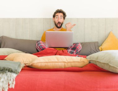 Genç sakallı adam inançsızlıktan şaşkın şaşkın bakıyor, yan taraftaki objeyi işaret ediyor ve diyor ki: