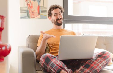 Genç sakallı adam neşeyle gülümsüyor, mutlu hissediyor ve fotokopi odasında bir konsept gösteriyor.