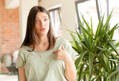 Güzel bir kadın şaşkın, şaşkın ve güvensiz hissediyor, kendini gösterip kim olduğunu soruyor, ben mi??