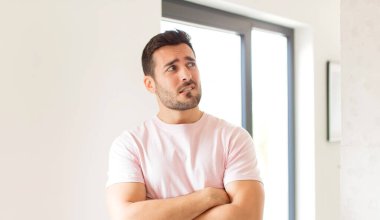 Yakışıklı bir adam şüphe ediyor ya da düşünüyor, dudağını ısırıyor ve kendini güvensiz ve gergin hissediyor.