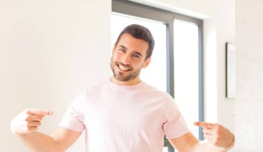 Yakışıklı, gururlu, kibirli, mutlu, şaşırmış ve tatmin olmuş, kendini gösteren, kazanan gibi hisseden bir adam.