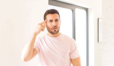 Yakışıklı adam şaşkın ve şaşkın hissediyor, deli, deli ya da aklını kaçırmış olduğunu gösteriyor.