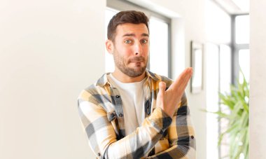 Yakışıklı bir adam kafası karışık ve bilgisiz, şüpheli bir açıklama ya da düşünceyi merak ediyor.