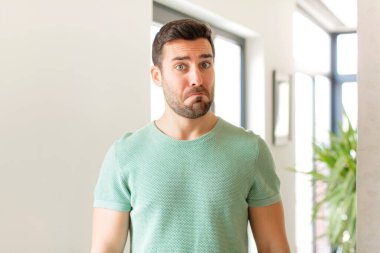 Yakışıklı bir adam üzgün ve stresli, kötü bir sürpriz yüzünden üzgün, olumsuz, endişeli bir bakışla