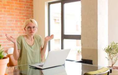 Güzel öğrenci şaşkın ve şaşkın hissediyor, şüpheci, farklı seçenekleri tartıyor ya da komik ifadeyle seçiyor.