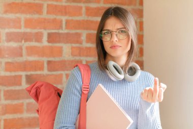 Güzel öğrenci kızgın, sinirli, isyankar ve agresif orta parmağını sallayarak karşılık veriyor.