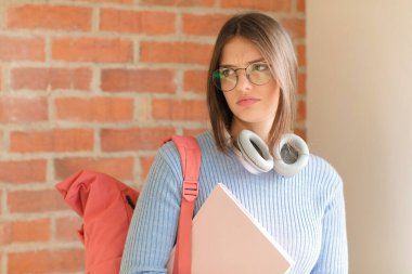 Güzel bir öğrenci üzgün, üzgün ya da kızgın. Olumsuz bir tavır takınıyor, anlaşmazlık içinde kaşlarını çatıyor.