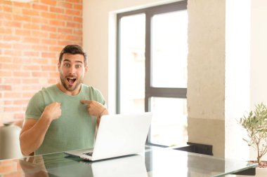 Yakışıklı adam mutlu, şaşkın ve gururlu, heyecanlı, şaşkın bakışlarla kendini işaret ediyor.