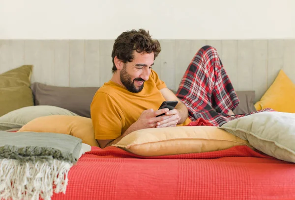 Junger Bärtiger Mann Auf Einem Bett Mit Seinem Handy — Stockfoto