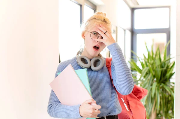 Ładna Studentka Wyglądająca Zszokowaną Przestraszoną Lub Przerażoną Zakrywająca Twarz Dłonią — Zdjęcie stockowe