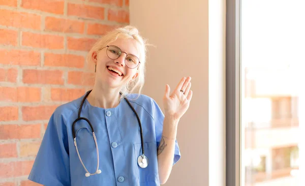 Ładna Pielęgniarka Uśmiechnięta Szczęśliwie Radośnie Machająca Ręką Witająca Pozdrawiająca Cię — Zdjęcie stockowe
