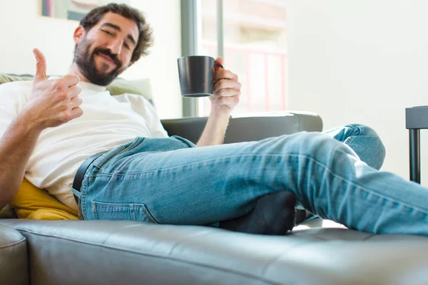 Jovem Barbudo Homem Descansando Sofá Com Uma Caneca Café — Fotografia de Stock