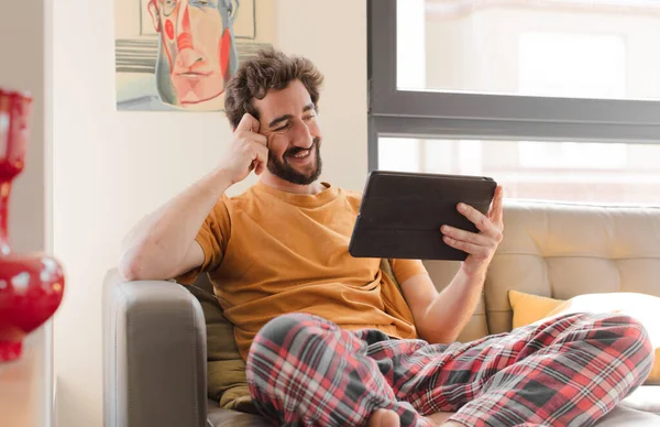 Junger Bärtiger Mann Auf Einer Couch Mit Einem Touchscreen Tablet — Stockfoto