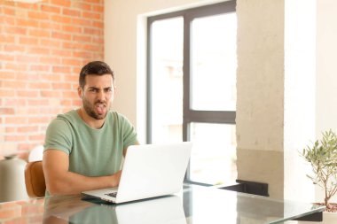 Yakışıklı bir adam tiksinmiş ve rahatsız olmuş hissediyor. Dilini dışarı çıkarıyor. Çirkin ve iğrenç bir şeyden hoşlanmıyor.