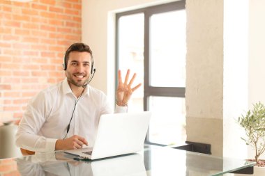 Yakışıklı pazarlamacı gülümsüyor ve arkadaş canlısı görünüyor. Elleri önde, geriye doğru sayıyor.
