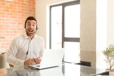 Yakışıklı pazarlamacı mutlu ve hoş bir şekilde şaşırmış görünüyor. Büyülenmiş ve şok olmuş bir ifadeyle heyecanlanıyor.