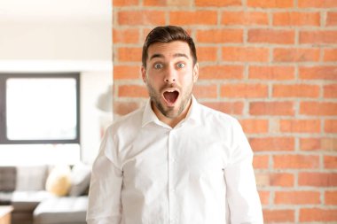Yakışıklı iş adamı çok şaşırmış ya da şaşırmış görünüyor, ağzı açık bir şekilde 