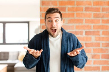 Yakışıklı, ağzı açık ve şaşırmış, şok olmuş ve hayrete düşmüş bir adam.