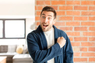 Yakışıklı adam mutlu, pozitif ve başarılı hissediyor, bir meydan okumayla karşılaştığında motive oluyor veya iyi sonuçları kutluyor.