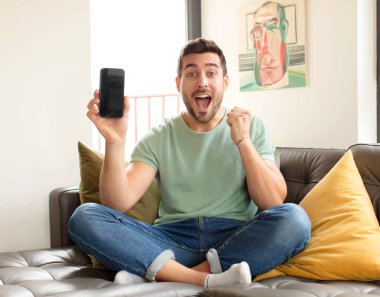 Yakışıklı adam şoke olmuş, heyecanlı ve mutlu, gülüyor ve başarıyı kutluyor.!