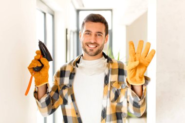 Becerikli adam gülümsüyor ve arkadaş canlısı görünüyor, 4 ya da 4 numarayı gösteriyor, eli önde, geriye doğru sayıyor.