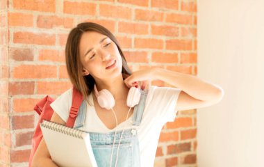 Stresli, endişeli, yorgun ve hayal kırıklığına uğramış, gömleğini çekmiş, sorunlu görünüyor.