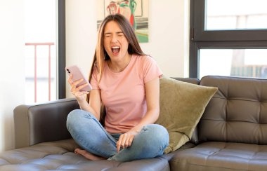 Güzel bir kadın agresif bir şekilde bağırıyor, sinirli, sinirli, öfkeli ya da sinirli görünüyor, hayır diye bağırıyor.