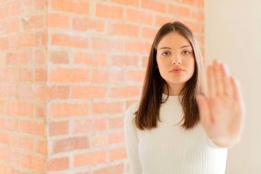 Genç bir kadın ciddi, sert, hoşnutsuz ve kızgın görünüyor.