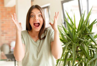 Güzel bir kadın beklenmedik bir sürpriz yüzünden şaşkın ve heyecanlı, gülen, şaşırmış ve mutlu hisseder.