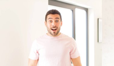 Yakışıklı adam çok şaşırmış ya da şaşkın görünüyor, ağzı açık bir şekilde 